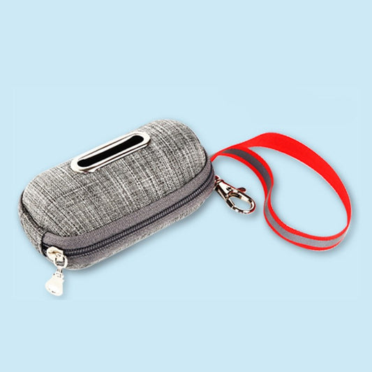 Grey fabric poop-bag dispenser pouch with a zipper and a red wrist strap with clip, on a light blue background.