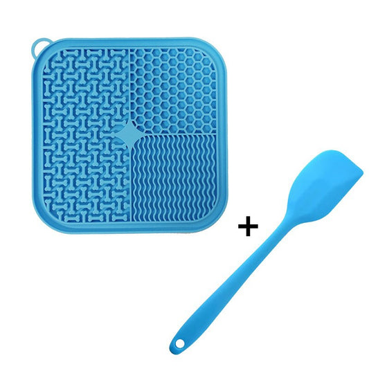 Blue silicone lick mat with suction cups and a matching silicone treat spatula, on a white background.