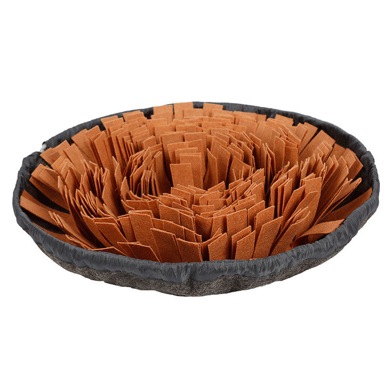 Round grey snuffle mat with orange fabric strips folded to hide treats, on a white background.