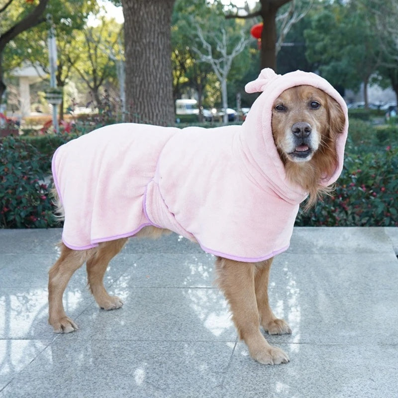 Golden retriever wearing pink SnugRobe bathrobe outdoors, full side profile